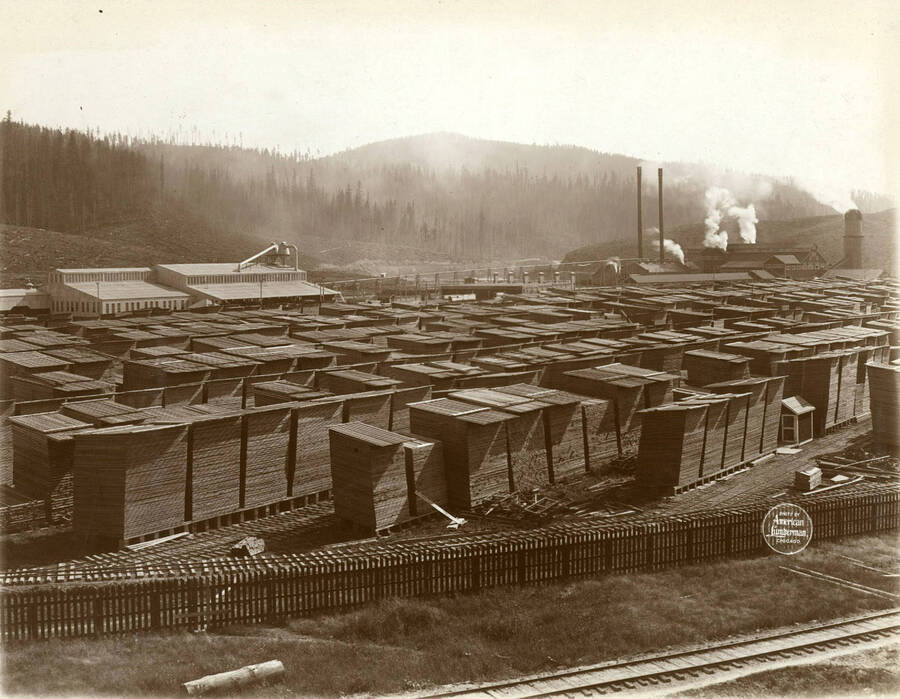 Close view of center of lumber yard, with planing mill, dry kilns, and saw mill in background. Description taken from American Lumberman papers found within the folder. Photograph taken between September 28 and October 4.