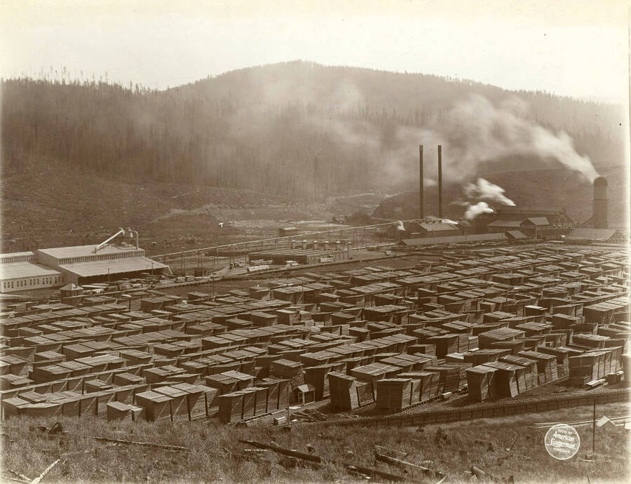 Close view of center of lumber yard, with planing mill, dry kilns, and saw mill in background. Description taken from American Lumberman papers found within the folder. Photograph taken between September 28 and October 4.