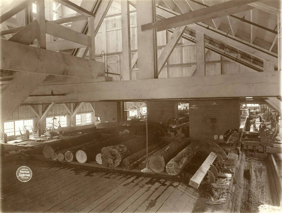 Interior of saw mill from log end, showing three Diamond Iron Works band mills. Description taken from American Lumberman papers found within the folder. Photograph taken between September 28 and October 4.