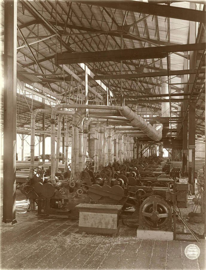 Line of Berlin machines in the planing mill, from north, showing Westinghouse motor at first machine. Description taken from American Lumberman papers found within the folder. Photograph taken between September 28 and October 4.