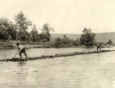 Two men ride a log raft. Written on the photograph is '5/29/1926 No. 36'
