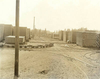 The lumber yard at the Rutledge Mill in Coeur d'Alene, Idaho. Also pictured in the photograph is the train system used to move lumber from place to place