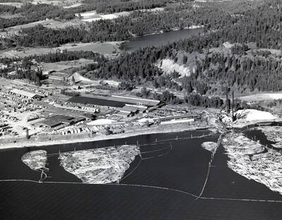 An aerial photograph of the Rutledge Mill in Coeur d'Alene, Idaho. Shown are the mill itself as well the log pond. On the back of the photograph is 'Western Ways, Inc. Aerial Photographic Specialists 275 Vera Drive Corvallis Oregon, Phone 35266