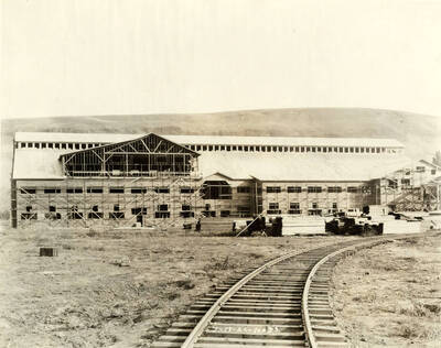 Scaffolding runs the side of one of the buildings under construction. Running from the bottom of the photograph to the right of the photograph are a set of railroad tracks. Written on the photograph is '7/13/1926 No. 73'