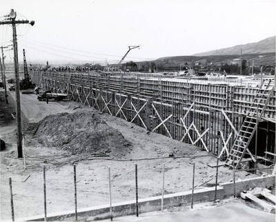 Construction of the Clearwater paper mill. Men work on the roof in the background.