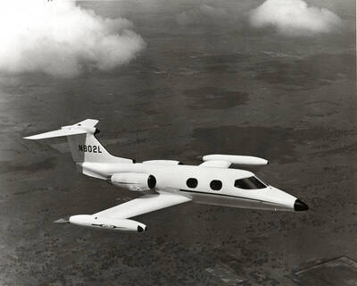 A Learjet jet with the tail number of N802L in flight.