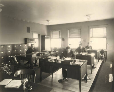 Men at their desk in the Sales Dept. Note the old Dictaphones.