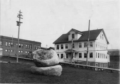 Granite boulders from Elk Butte, near Elk River, Idaho, placed on the lawn of the Potlatch Gymnasium and club house in memory of William Deary, formerly general manager of Potlatch Lumber Company' [Description taken from back of photograph]. The white house in the background still stands and is now the Potlatch City Hall.