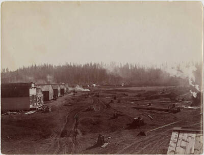 The first 'Main' street in Potlatch, Idaho. The description on the back of the photograph reads 'Temporary store and boarding houses near mill pond and just south of the barn and sawmill.'
