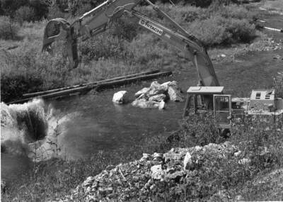 A boulder makes a big splash after being dumped by an excavator into the Orogrande Creek. Boulders and logs are being put into the creek to help make it deeper and provide a home to fish.
