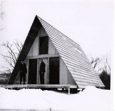 Two men stand in front of an A-Frame house made from Potlatch products.