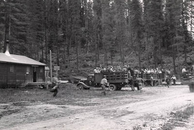 Men run to get into pickup trucks already filled with men.