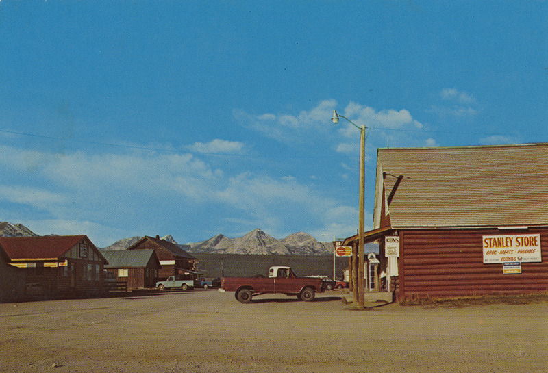 Postcard of the Stanley Store in Stanley, Idaho with the Sawtooth Mountains in the background.