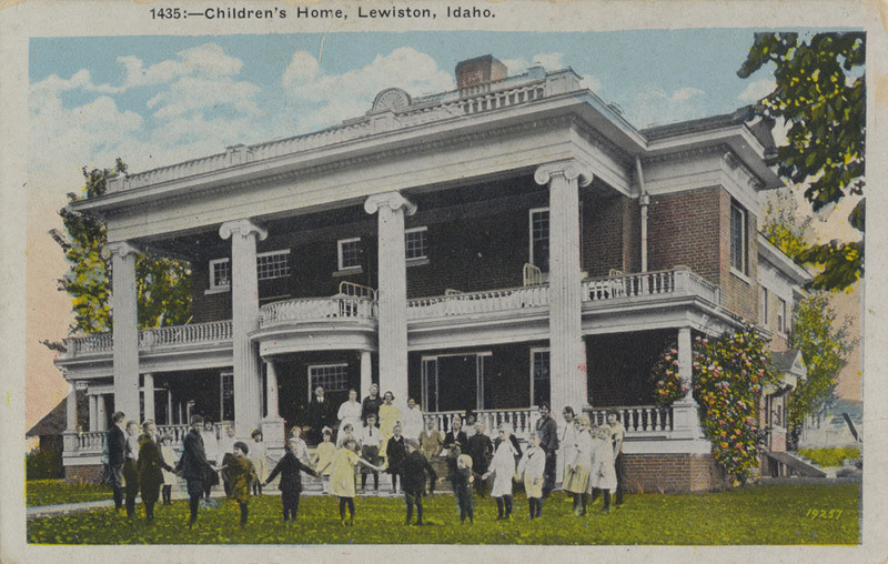 Postcard of children and adults posing in front of the Children's Home in Lewiston, Idaho.