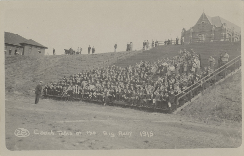Postcard of a coach talking to students and athletes before a game in 1915.