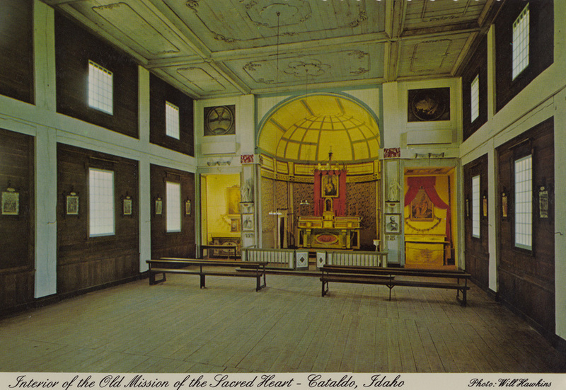 Postcard of the interior of the Cataldo Mission church in Cataldo, Idaho. | The interior of the "Old Mission" of the Sacred Heart looks today much as it would have when it was part of a thriving Indian/Jesuit mission in the 1860's. The artistic genius of Father Ravailli, the church's architect and designer, is revealed in the two wood carvings on either side of the altar. Built in 1848-53, it remains as Idaho's oldest building. The "Old Mission State park" is open year around to visitors.