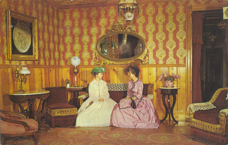 Postcard of two women sitting in the lobby of a hotel in Virginia City, Montana. | The elegance of the 1860's, western hospitality, and modern day comfort await you. Historic Virginia City, Montana.