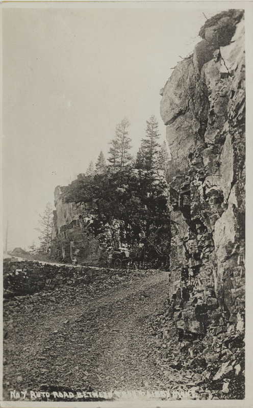 Postcard of a road between Troy and Libby, Montana.