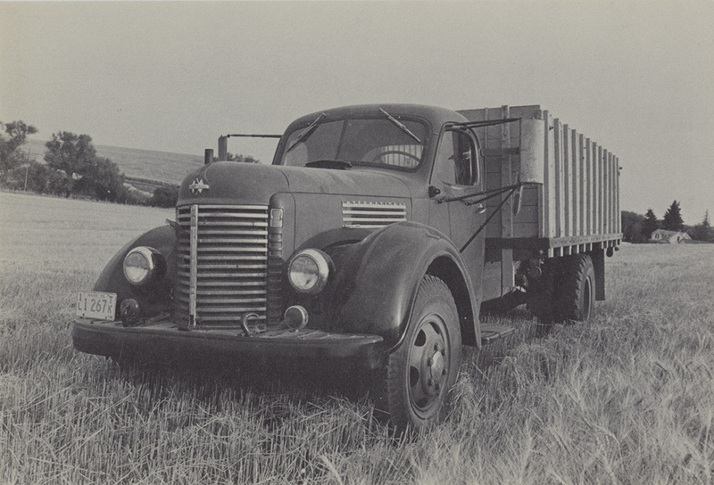 Postcard of a truck in a grain field near Moscow, Idaho. | Grain truck parked in a wheat field, waiting to be filled, August. This photograph is one of the many striking images of Palouse farm life included in Bill Woolston's Harvest. A hardbound, 128-page book published by Thorn Creek Press, Genesee, Idaho, 83832, Harvest is available in your local bookstore or direct from the publisher.