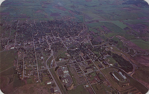 Postcard is an aerial photograph of Moscow, Idaho and the University of Idaho. | University of Idaho, and Moscow, progressive host city of 12,000, located among the fertile plaid fields of the Palouse. Although the University owns 1200 acres, most of the buildings are clustered in a compact, slightly undulating campus, which makes for an atmosphere of casualness among the 4400 students.