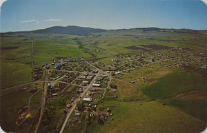 Postcard is an aerial photograph of Cottonwood, Idaho. | Cottonwood in North Idaho. Population 1,100, elevation 3440 on Hwy 95, part of the rich Camas Prairie. Its history dates back to the 1860's, when it was sit of a way-station for mine supplies. Cottonwood was the scene of a skirmish in the Nez Perce War of '77. Fine schools and churches, a diversified economy and recreation make this town attractive for family living.