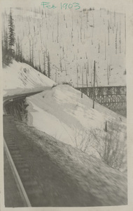 Postcard of snow near a railroad trestle after a snow slide.