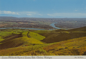 Postcard of Lewiston, Idaho and Clarkston, Washington and the confluence of the Clearwater and the Snake Rivers. | Long one of the west's great spectacles (the view will always be!) this tortuous road is being replaced by a new highway, out of view at left. 10 miles of continuous curves descent 2,000 vertical feet to Lewiston (Idaho's only seaport) and Clarkston, Washington (right). Two large rivers, the Clearwater (left) and Snake join in the scene. The area boasts the North-west's mildest year-around temperature.