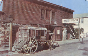 Postcard of a wagon near a historic building in Virginia City, Montana.