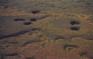 Postcard of sinkholes in lava flows in Craters of the Moon National Monument, Idaho. | Craters of the Moon National Monument, Idaho. Lava sinks. Seen from the air, sink holes in pahoehoe lava flows mark places where the lava surface collapsed. Early settlers imagined a resemblance to the moon's surface as seen through a telescope, hence the name "Craters of the Moon"