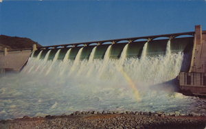 Postcard of the spillway of the Grand Coulee Dam in Washington state.  | A wall of water 1,650 feet long and 17 fee thick plunges over the Grand Coulee Dam in a 320-foot fall during the average high-water season. Fortunately for tourists and for the million-acre Columbia Basin Irrigation Project in central Washington, the glacier fed Columbia River has its greatest flow in the summer months.