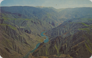 Postcard is a view of the Snake River Canyon between Idaho and Oregon.  |  Snake River Canyon on Idaho Line, as viewed up this rugged and tortuous river. This is part of Hells Canyon, 5500 ft. deep - deepest on the continent. The Seven Devils, 9410 ft., are in the background, set aside as a Forest Service Scenic area.