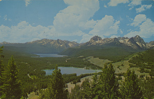 Postcard is of Little and Big Redfish Lakes in the Sawtooth Mountains in Idaho.  | Little Redfish - Big Redfish Lakes in the Sawtooth National Forest. Located in the Idaho Primitive Area. The Sawtooth Range is in the background. Camping and lodge facilities are available throughout the area.