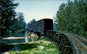Postcard of a covered railroad bridge near Monroe, Washington. | Monroe, Snohomish County, Washington. 1 mile So. East of business district. Longest covered railroad span in the U.S. 450' 3 spans across the Skykomish River.
