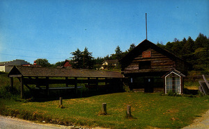 Postcard of the Alexander Blockhouse in Coupeville, Washington.  | Alexander Blockhouse and Indian dug-out canoes, Coupeville, Washington.