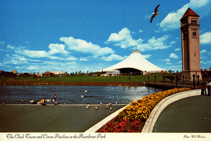 Postcard of the clock tower and circus pavilion in the Riverfront Park area of Spokane, Washington. | The Clock Tower and Circus Pavilion in the Riverfront Park. Photo: Will Hawkins. These two structures are the focal points of this delightful city park along the Spokane River in downtown Spokane, Washington, as they were during the World's Fair. Beautiful floral plantings grace the walkways; and gentle, grass covered slopes enhance the atmosphere. Many ducks and seagulls feed on the river and readily accept handouts from sympathetic visitors. The Great Northern Clock Tower is the last remnant of the railroad depot and maze of tracks once occupying this site.