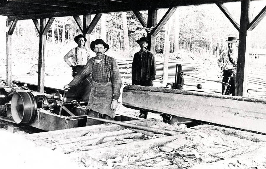 Art Marsten (front) running the sawmill as three other men look on. Coolin Bay, Idaho. Donated by Marjorie (Paul) Roberts through Priest Lake Museum.