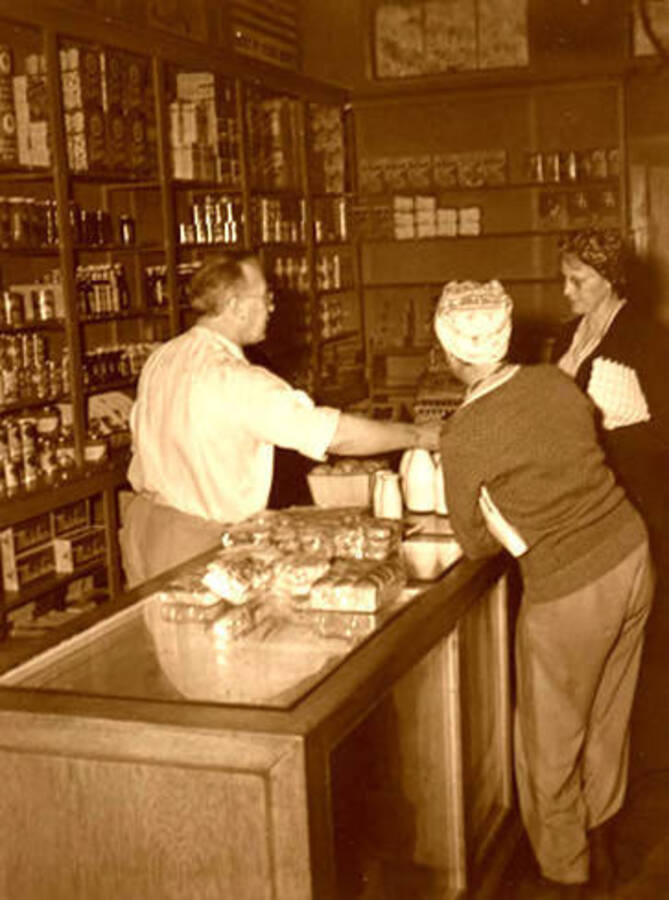 Leonard Paul at the counter inside his store in Coolin, Idaho. Donated by Marjorie Paul Roberts via Priest Lake Museum.