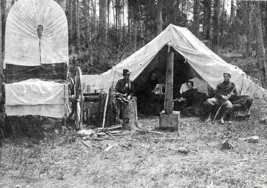 The E. S. Burgan Family while camping. A covered wagon sits next to the tent.