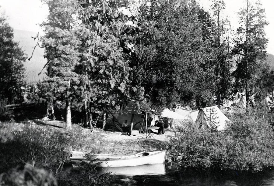 Tents and rowboat along the shore. Priest Lake, Idaho.