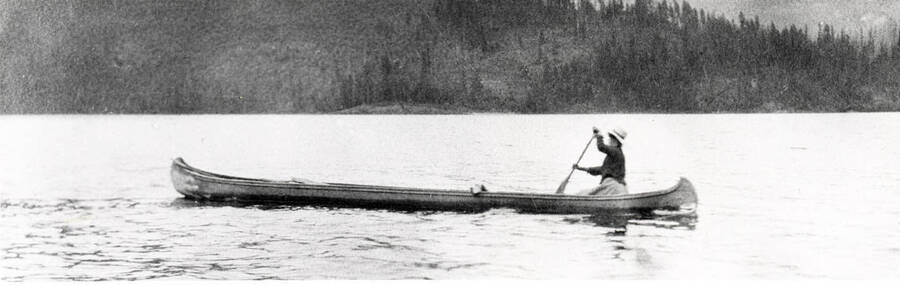Side view of a woman and a dog in canoe. Donated by Harriet (Klein) Allen through Priest Lake Museum.