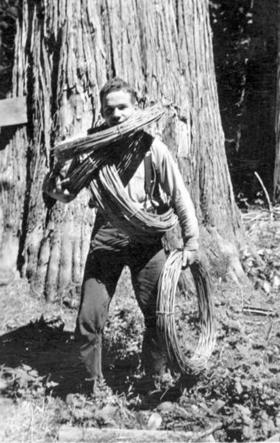 A man rolling up telephone lines from Kaniksu Mountain. No. 9 wire. Near Priest Lake, Idaho. Donated by G. Black through Priest Lake Museum.