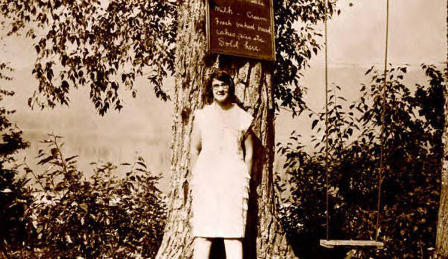 Astor Calfee standing next to a sign. Donated by Margaret Randall through Priest Lake Museum.