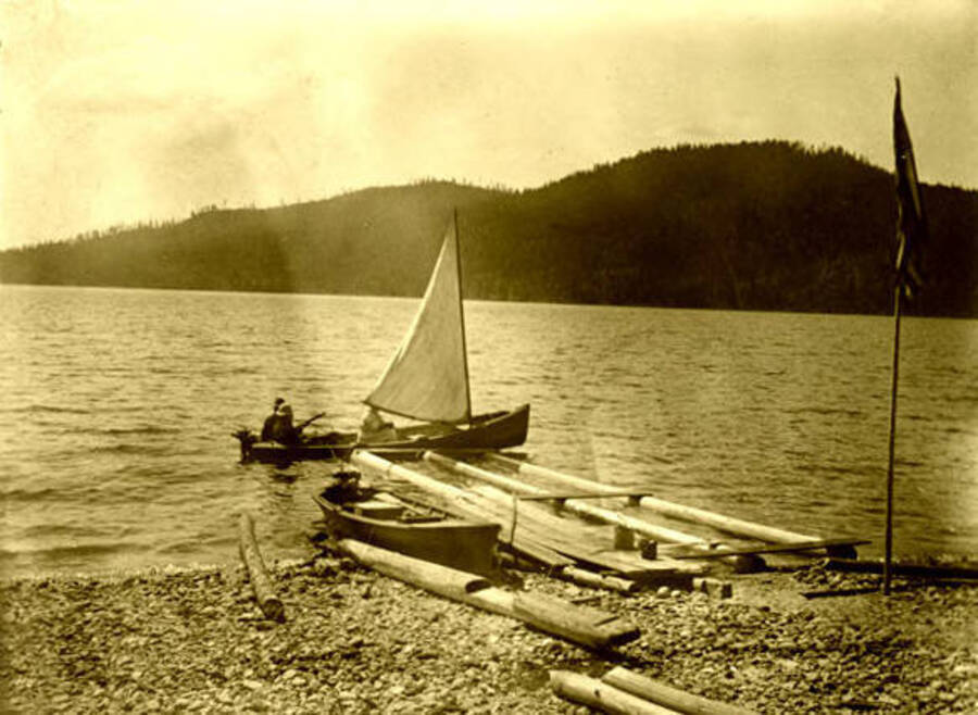 A small moter sailboat near a dock on Priest Lake, Idaho. Donated by Harriet (Klein) Allen via Priest Lake Museum.
