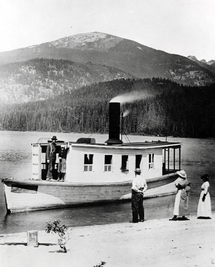 The steamboat W. W. Slee near the beach. People can be seen on the boat and along the shore. Lookout Mountain is in the background. Donated by Harriet (Klein) Allen through Priest Lake Museum.