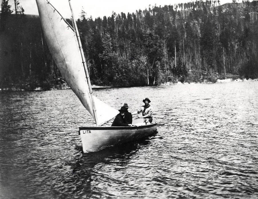 Sailboat 'Lita' with three men and a dog aboard. Donated by Harriet (Klein) Allen through Priest Lake Museum.