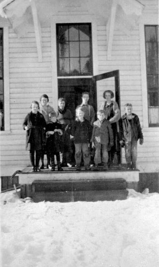 Eight students and a teacher stand on the steps of Coolin School in Coolin, Idaho. Donated by Mike Winslow through Priest Lake Museum.