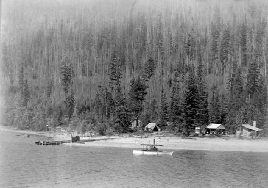 Boats in front of cabins flying flags. Priest Lake, Idaho. Donated by Stan McClung through Priest Lake Museum.