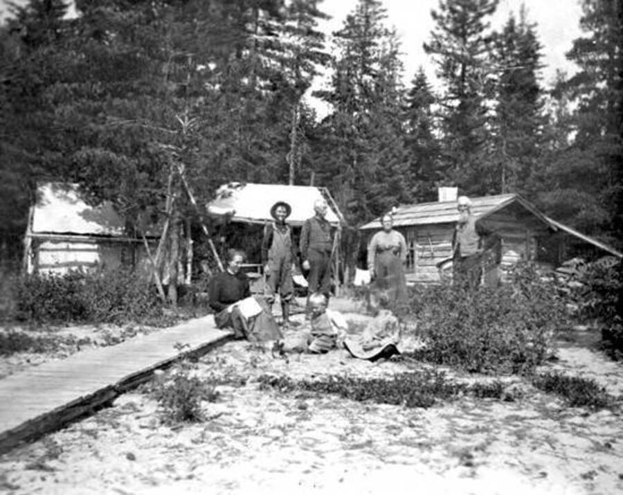 The Fish family on wooden walkway in front of cabins. Donated by Stan McClung through Priest Lake Museum.