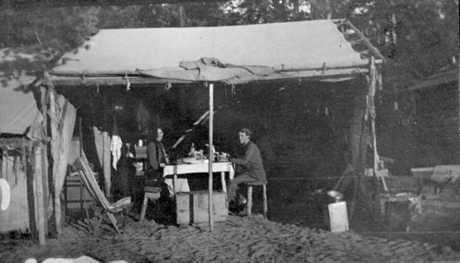 People sitting in a camp's kitchen area. Donated by Stan McClung through Priest Lake Museum.