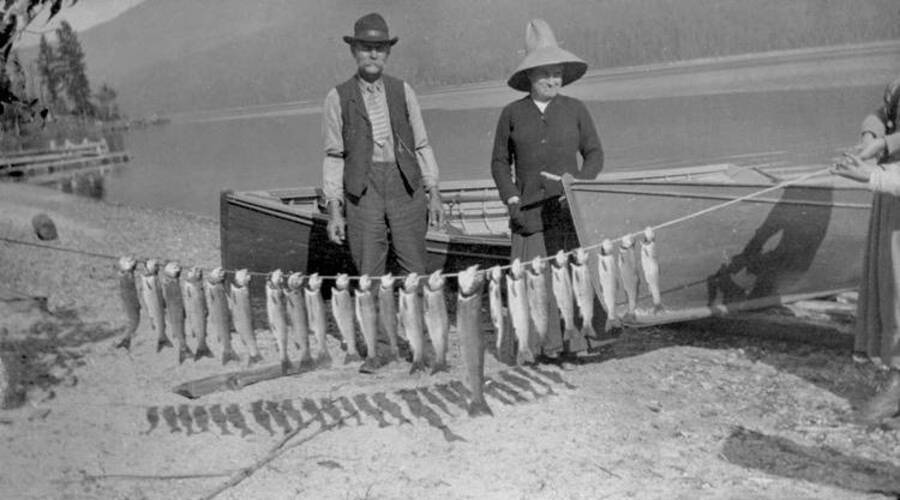 Two men pose with a days worth of fish caught. Donated by Stan McClung through Priest Lake Museum.